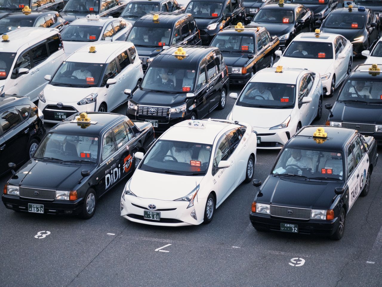 Taxis lined up in a parking lot, showcasing urban transportation in Japan.
